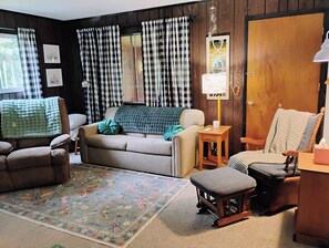 A cozy living room with a sofa, armchairs, a small table, and a patterned rug. - Pet-Friendly, Cozy 2-bedroom cabin near crystal blue Wood Lake with AC (Westfield)