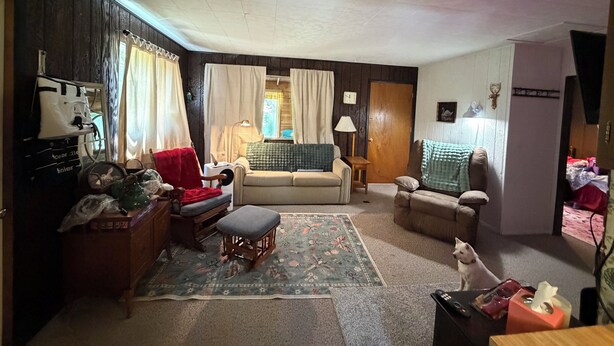 Ein Wohnzimmer mit einer Couch, einem kleinen Tisch, einer Lampe und einem Hund.
