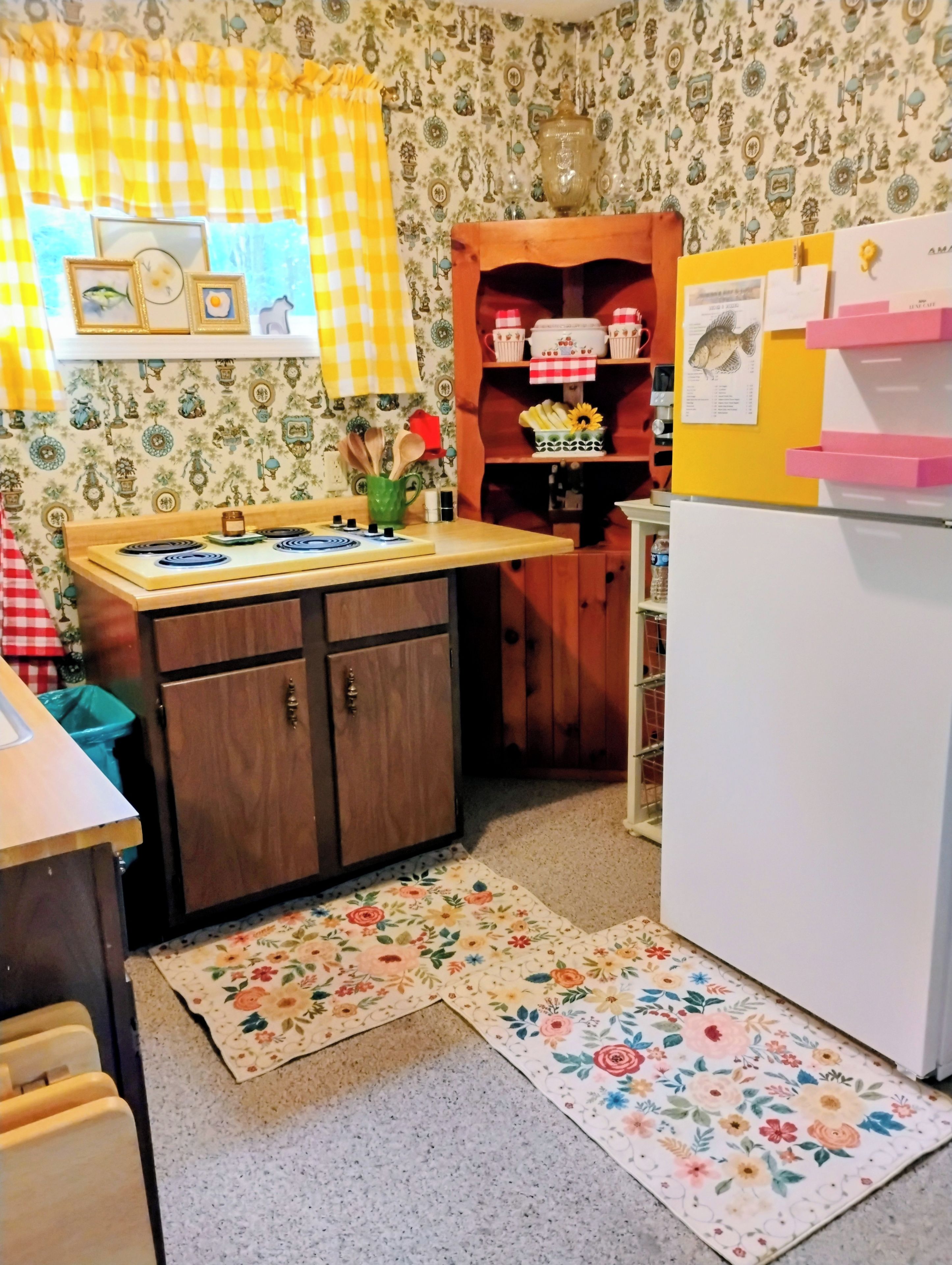 A kitchen with a wooden cabinet, a white refrigerator, and a patterned backsplash.