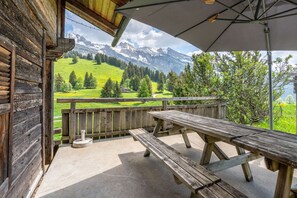 A wooden deck with picnic tables overlooking a mountainous landscape. - Ravoux : Chalet, terrasse  et  vue montagne (LA CLUSAZ)
