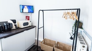 A kitchenette with a microwave, coffee maker, and a TV mounted on the wall. - The Bay Apart-Hotel by Guestz (Morecambe)