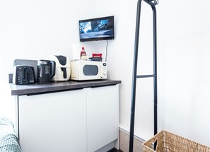 A kitchenette with a toaster, coffee maker, microwave, and a TV mounted on the wall. - The Bay Apart-Hotel by Guestz (Morecambe)