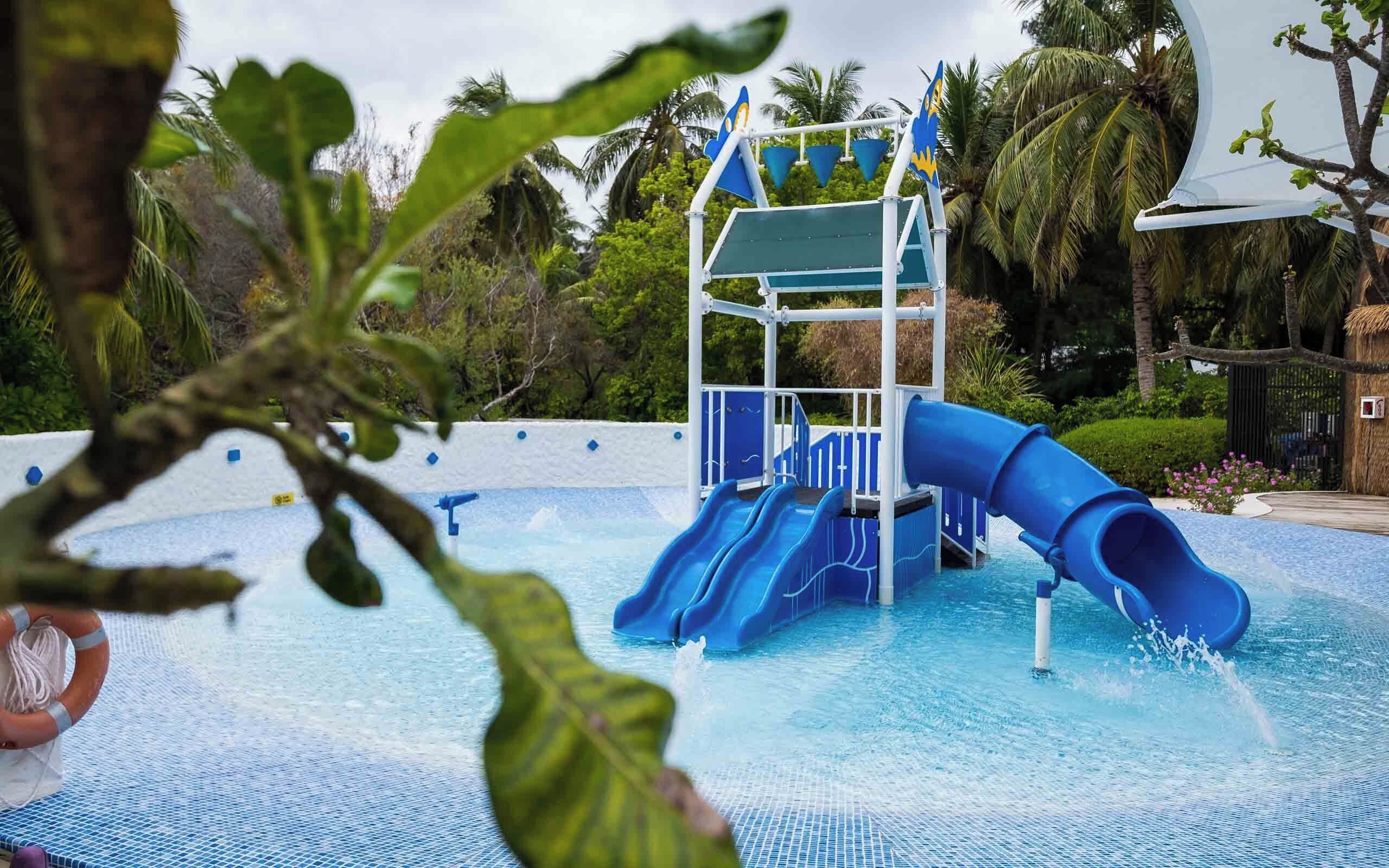 A water park with a blue slide and a water play area.