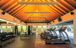A gym with treadmills, dumbbells, and weight machines.