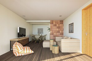 A modern living room with a wooden floor, a sofa, a TV, a dining area with chairs, and a wooden door. - Kandooma Maldives - All Inclusive with Kids Stay & Eat Free (Kandooma)
