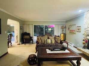 Ein Wohnzimmer mit Sofa, Sessel, Couchtisch und einer Steinwand.