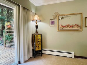 Ein Zimmer mit Fenster, Lampe, Heizkörper und einem gerahmten Bild an der Wand.