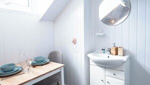 Ein Zimmer mit einem Holztisch, einem weißen Waschbecken und einem Spiegel.