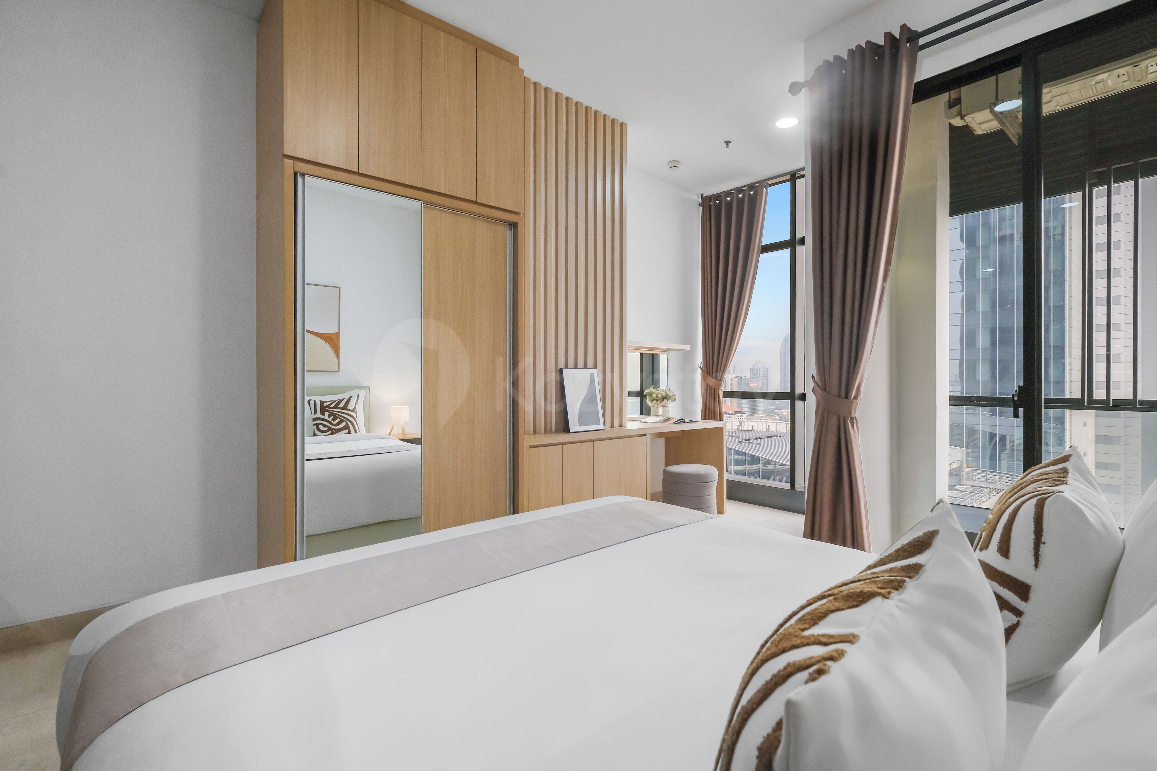 Une chambre d’hôtel moderne avec un grand lit, une armoire en bois, un bureau et une vue sur la ville.