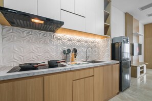 Eine moderne Küche mit Einbauofen, Edelstahl-Kühlschrank und Mikrowelle.