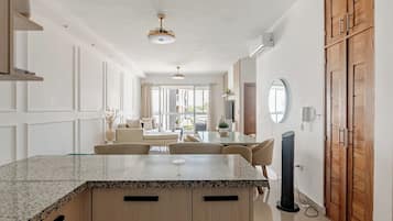 A modern kitchen with a granite countertop, wooden cabinets, and a dining area with a table and chairs.
