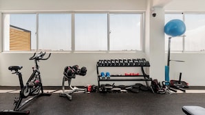 Et fitnessrum med træningsudstyr, en vægtstang og en blå træningsbold.