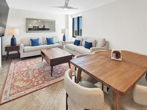 A modern living room with a sofa set, a wooden coffee table, and a dining table with chairs. - 3B/2B Seavista Beach Front Great View (South Padre Island)