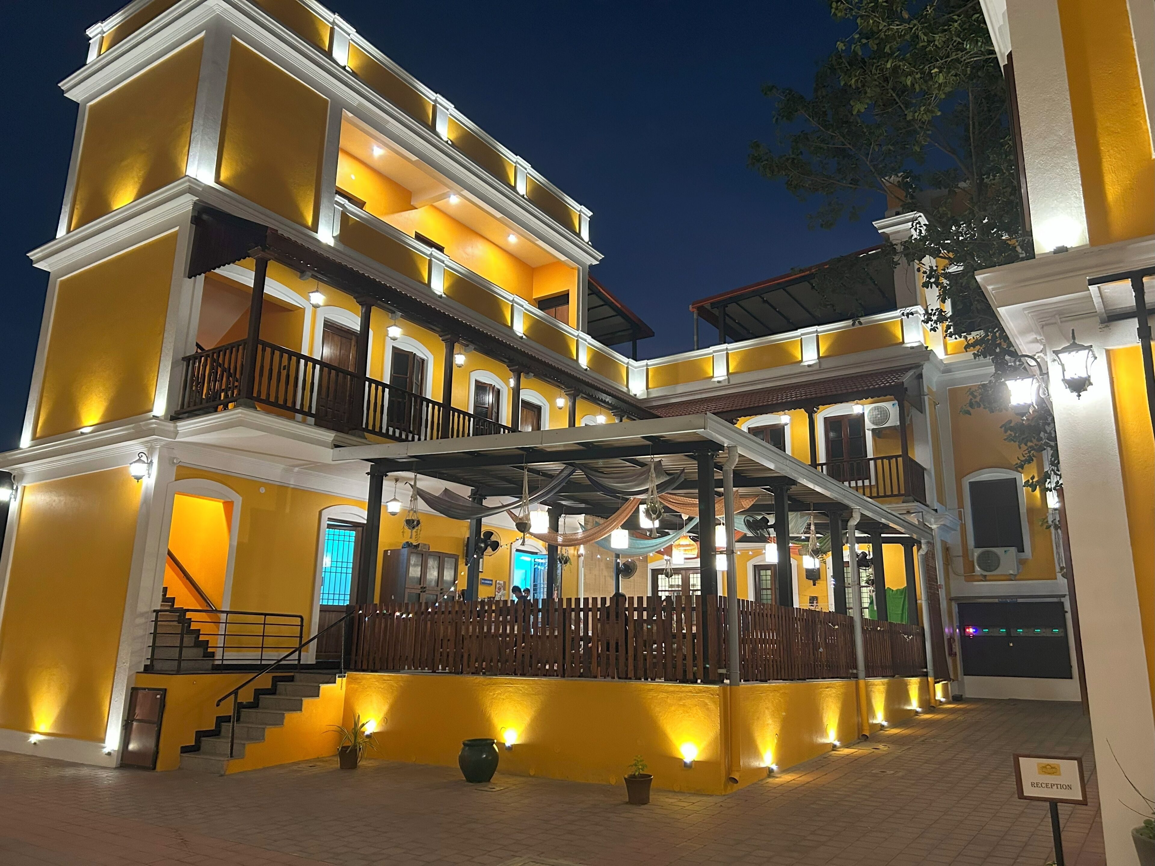 A multi-story building with a reception area, a staircase, and a covered outdoor seating area.