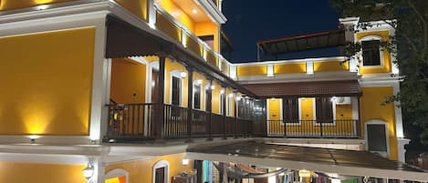 Un edificio de varios pisos con balcón y zona de estar al aire libre.