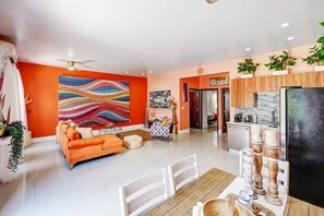 A modern living room with a sofa, a dining table, and a kitchen area with a refrigerator and cabinets. - Romantic 2Bed/2Bath/2K - 5★ DT Location -♛Hot Tub (Fort Lauderdale)