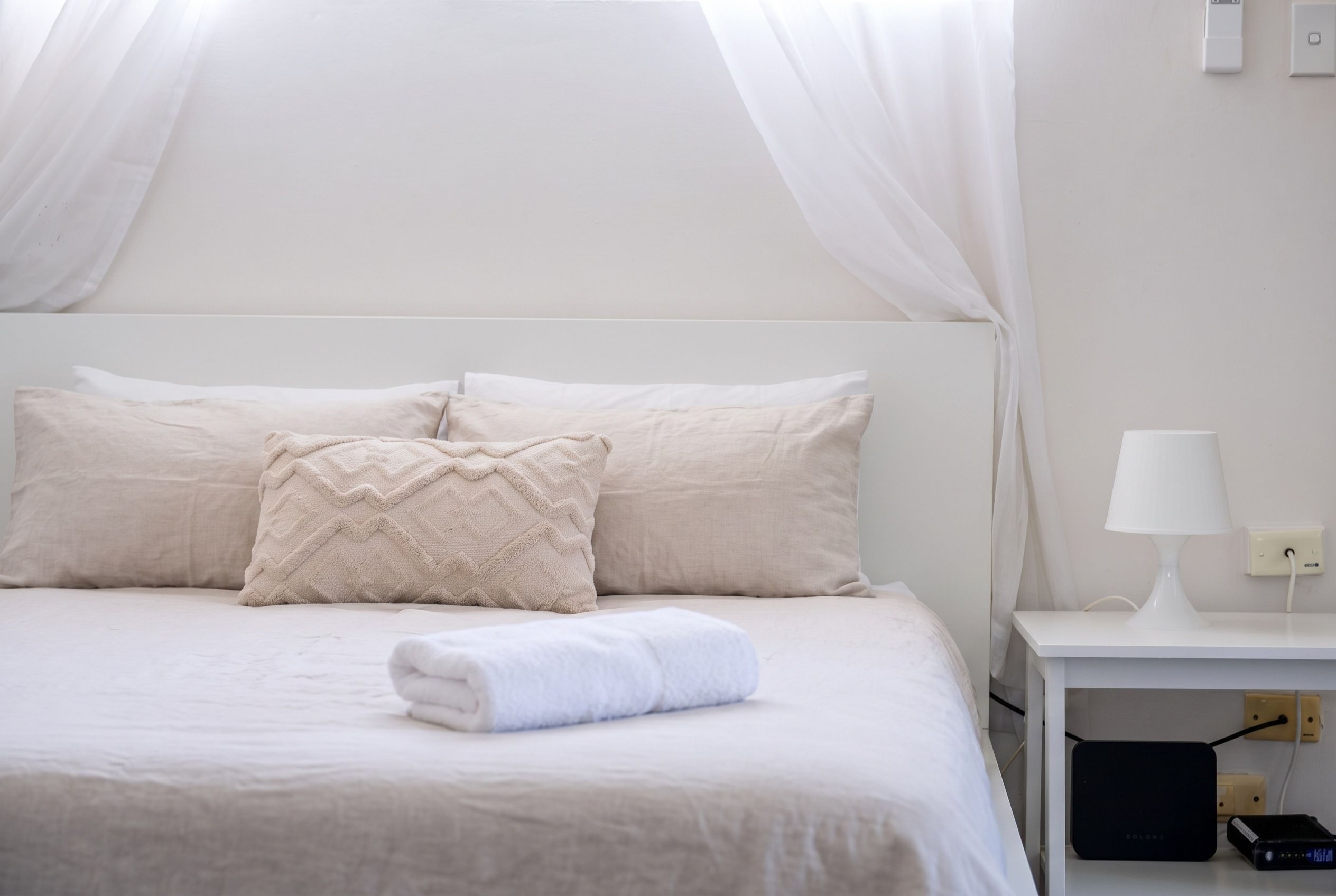 Queen bed made up with fresh white linen and towels