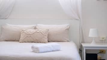 Queen bed made up with fresh white linen and towels