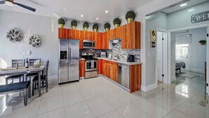 A modern kitchen with wooden cabinets, stainless steel appliances, and decorative plants. - Glamorous 2Bed/2Bath/2K- 5★ DT Location-♛Hot Tub (Fort Lauderdale)