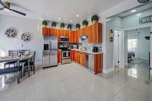 A modern kitchen with wooden cabinets, stainless steel appliances, and decorative plants. - Glamorous 2Bed/2Bath/2K- 5★ DT Location-♛Hot Tub (Fort Lauderdale)