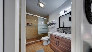 A modern bathroom with a wooden vanity, a white toilet, and a glass shower enclosure. - Glamorous 2Bed/2Bath/2K- 5★ DT Location-♛Hot Tub (Fort Lauderdale)