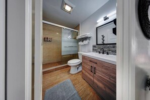 A modern bathroom with a wooden vanity, a white toilet, and a glass shower enclosure. - Glamorous 2Bed/2Bath/2K- 5★ DT Location-♛Hot Tub (Fort Lauderdale)