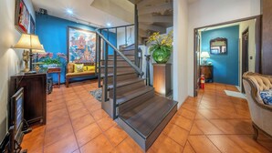 A staircase leading to a second floor, a sofa, a lamp, and a framed picture on the wall. - Aphirom Hometel (Bangkok)