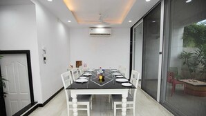 A dining area with a black table, white chairs, and a ceiling fan.