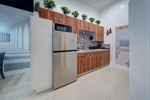 A modern kitchen with a stainless steel refrigerator, wooden cabinets, and a view to the sea. - ★Luxurious & Comfy★ - Close to Downtown - ♛Hot Tub (Fort Lauderdale)