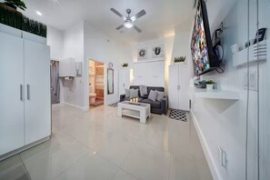 A modern living room with a sofa, coffee table, and a flat-screen TV mounted on the wall. - ★Luxurious & Comfy★ - Close to Downtown - ♛Hot Tub (Fort Lauderdale)