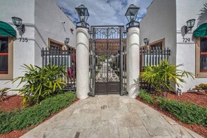 A gated entrance with a wrought iron gate, two columns, and a pathway leading to a building with the numbers 735 and 729 on the walls. - ★Luxurious & Comfy★ - Close to Downtown - ♛Hot Tub (Fort Lauderdale)