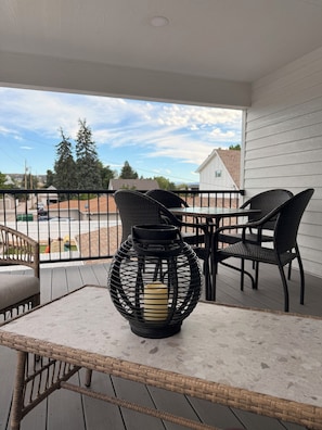 A balcony with wicker furniture and a decorative lantern.