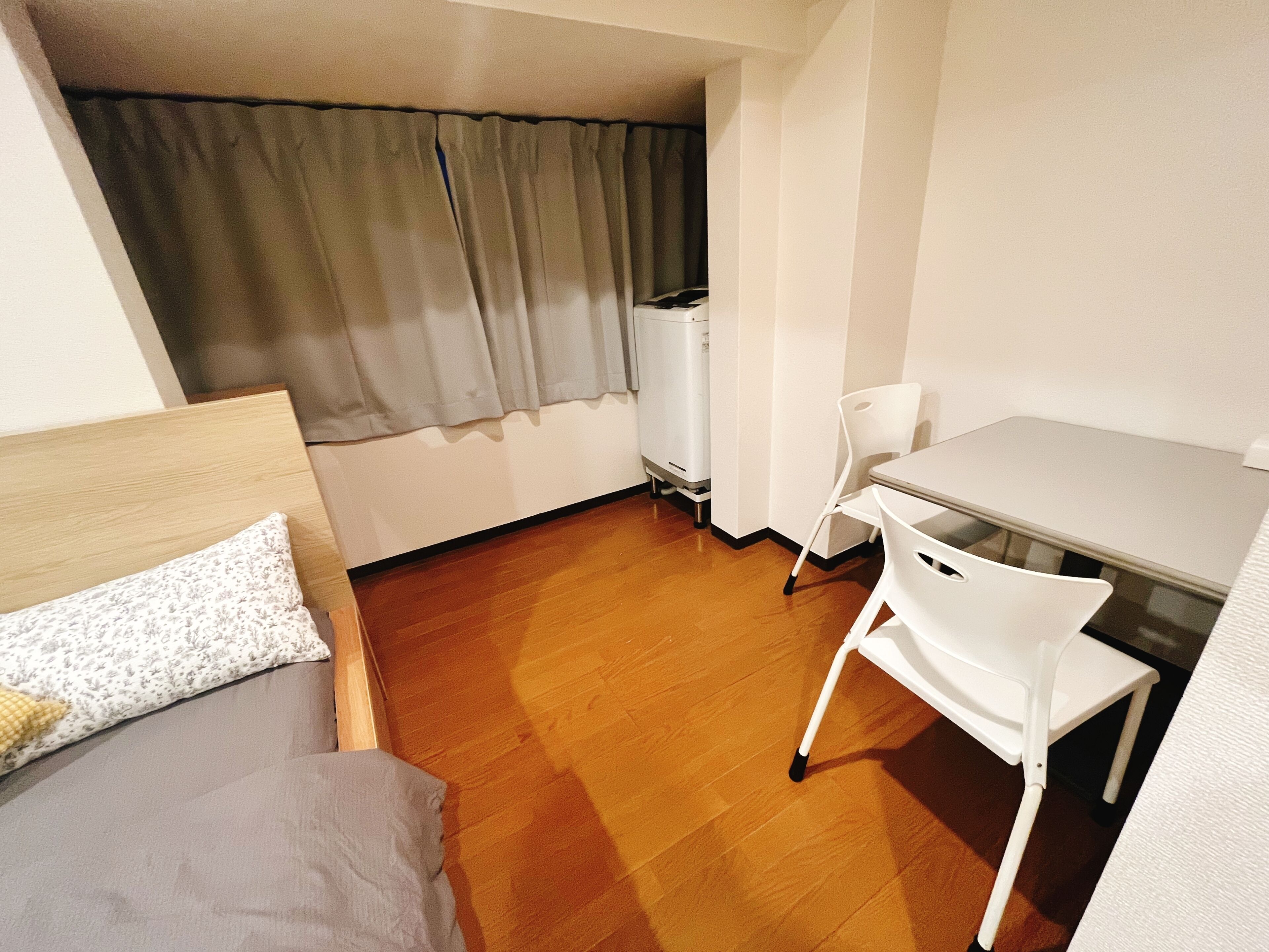 Una habitación pequeña y funcional con cama, escritorio y silla.