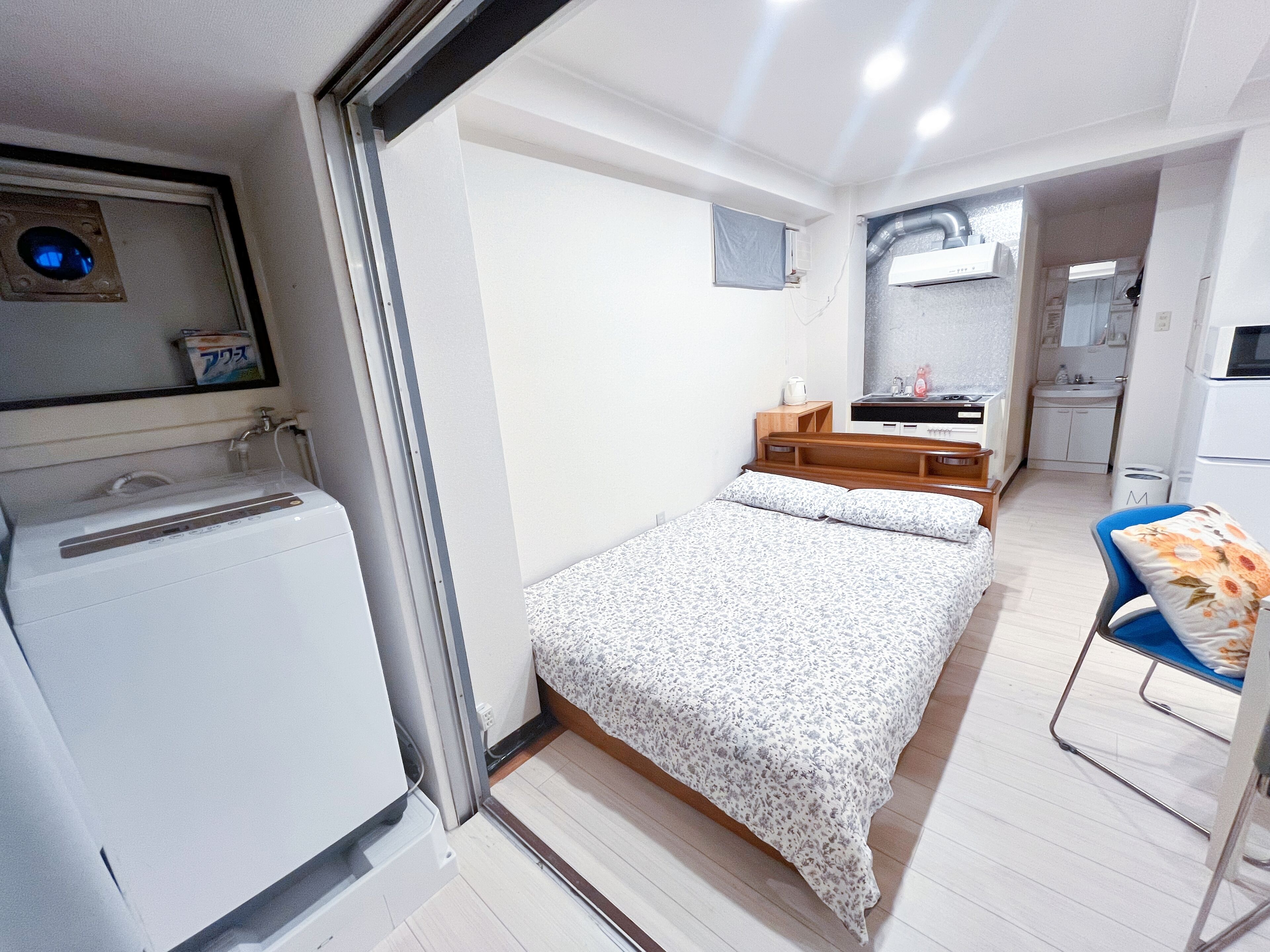 Une pièce de taille modeste comprenant un lit, une petite kitchenette et une salle de bain.