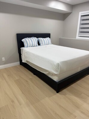 A bedroom with a bed, a headboard, and a window with blinds. - 5 Bedrooms deluxe, Hyde Park Mall and Western University area Sleep up to 10 (London)