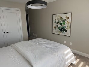 A bedroom with a bed, a wardrobe, a ceiling light, and a wall-mounted painting. - 5 Bedrooms deluxe, Hyde Park Mall and Western University area Sleep up to 10 (London)
