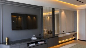 Un baño moderno con un espejo grande, un tocador con cajones y un banco.