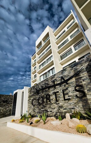 Ein mehrgeschossiges Hotel mit einer Stein-Fassade und einem Schild mit der Aufschrift 'Costa Cortes'.