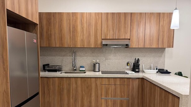 Una cocina moderna con armarios de madera, electrodomésticos de acero inoxidable y una encimera de granito.