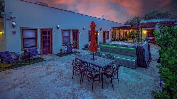 A patio with a table and chairs, a barbecue grill, and a hot tub. - ★The Riverwalk Getaway★ - Steps to DT - ♛Hot Tub (Fort Lauderdale)