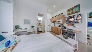 A modern hotel room with a large bed, a desk, and a kitchenette. - ★The Riverwalk Getaway★ - Steps to DT - ♛Hot Tub (Fort Lauderdale)