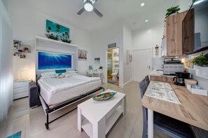 A compact hotel room with a bed, a desk, a kitchenette, and a bathroom. - ★The Riverwalk Getaway★ - Steps to DT - ♛Hot Tub (Fort Lauderdale)