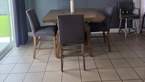 A dining area with a table, chairs, a ceiling fan, and a painting on the wall. - 3-bedroom house in tranquil Las Vegas with cool vibes (Las Vegas)
