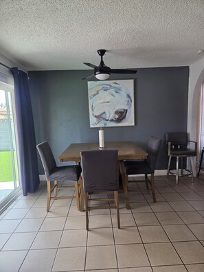 A dining area with a table, chairs, a ceiling fan, and a painting on the wall. - 3-bedroom house in tranquil Las Vegas with cool vibes (Las Vegas)
