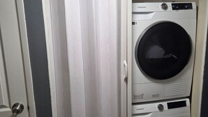 A laundry room with two stacked washing machines and a door. - 3-bedroom house in tranquil Las Vegas with cool vibes (Las Vegas)