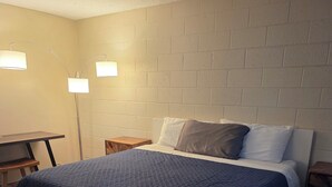 A bedroom with a bed, bedside tables, a desk, and two wall-mounted lamps. - 3-bedroom house in tranquil Las Vegas with cool vibes (Las Vegas)