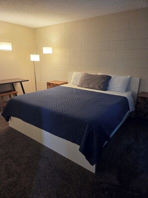 A bedroom with a bed, bedside tables, a desk, and two wall-mounted lamps. - 3-bedroom house in tranquil Las Vegas with cool vibes (Las Vegas)