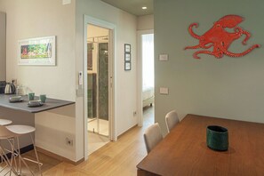 Eine moderne Küche mit Essbereich, einer Kaffeemaschine und einer großen Octopus-Dekoration an der Wand.