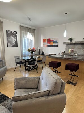 Ein modernes Wohnzimmer mit Sofa, Essbereich und Küchenbar.