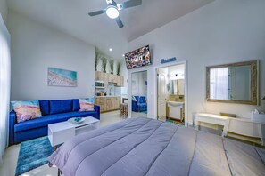 Une chambre moderne comprenant un lit, un canapé, un bureau et un coin cuisine.